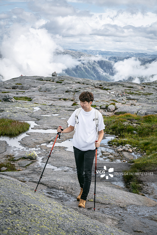 大自然之旅——一个穿着黄色雨衣在挪威克拉格徒步旅行的人图片素材