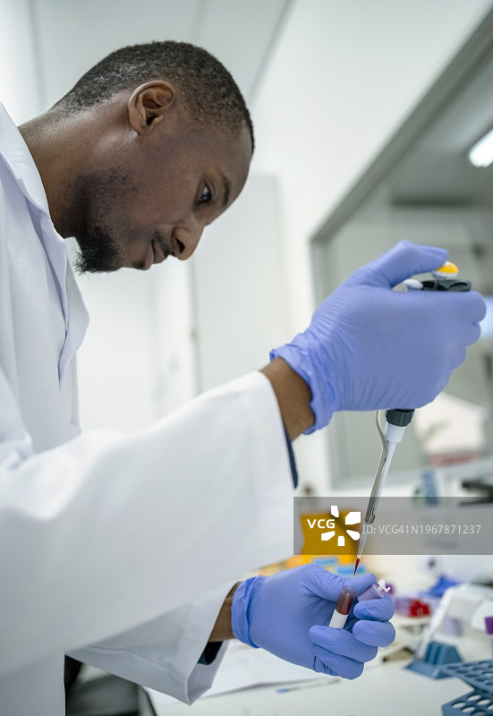 在病理实验室处理血液样本的非洲男性技术员图片素材