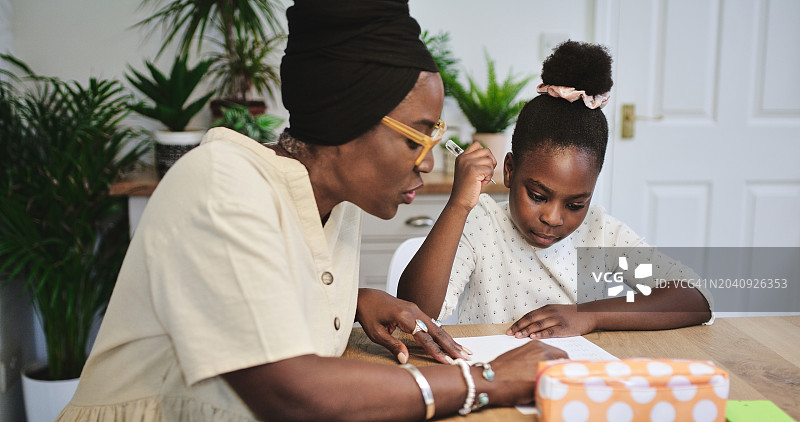 黑人母亲，孩子和在家里学习，在家庭学校的餐桌上一起教学和学习。妈妈，女孩和家庭教育，家庭作业辅导和阅读儿童发展的纸上知识图片素材