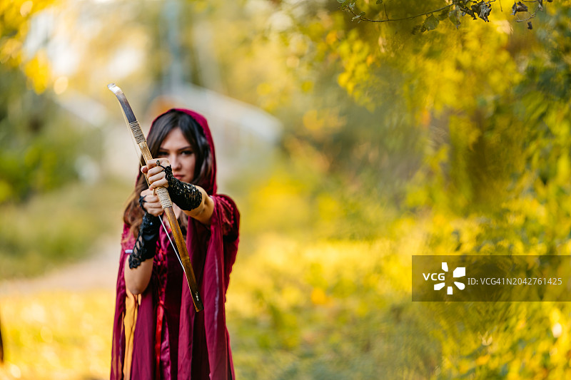 森林里拿着弓箭的神奇女人图片素材