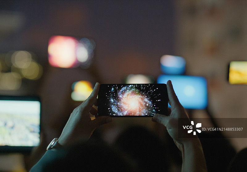 手机，手和屏幕上的星星，银河和天空的空间，在互联网上娱乐。技术，流媒体和照片星座科学，探索和信息或教育在黑暗中图片素材