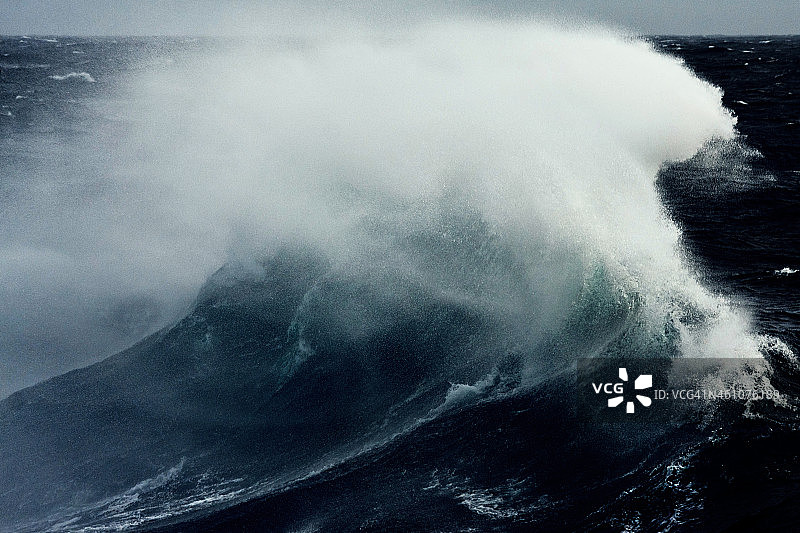 巨大的波浪在浩瀚的海洋中溅起水花图片素材