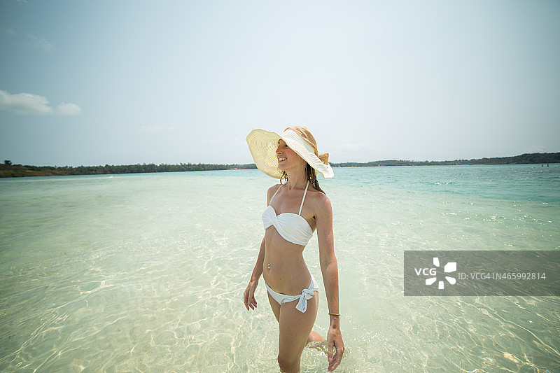 一名年轻女子走进了热带岛屿上清澈的海水中图片素材