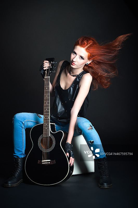 一个拿着吉他的红头发女人图片素材