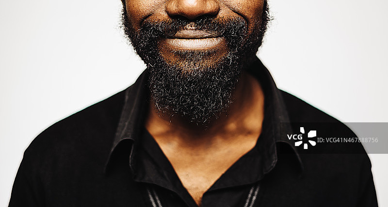 快乐的非洲中年男子肖像与胡子微笑。图片素材