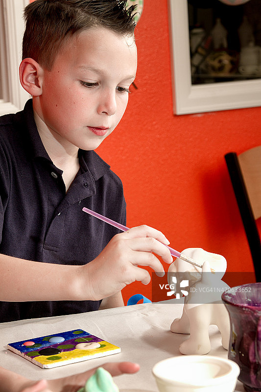 8岁白人男孩画陶器图片素材