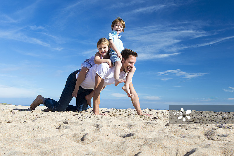 父亲和孩子们在海滩上图片素材