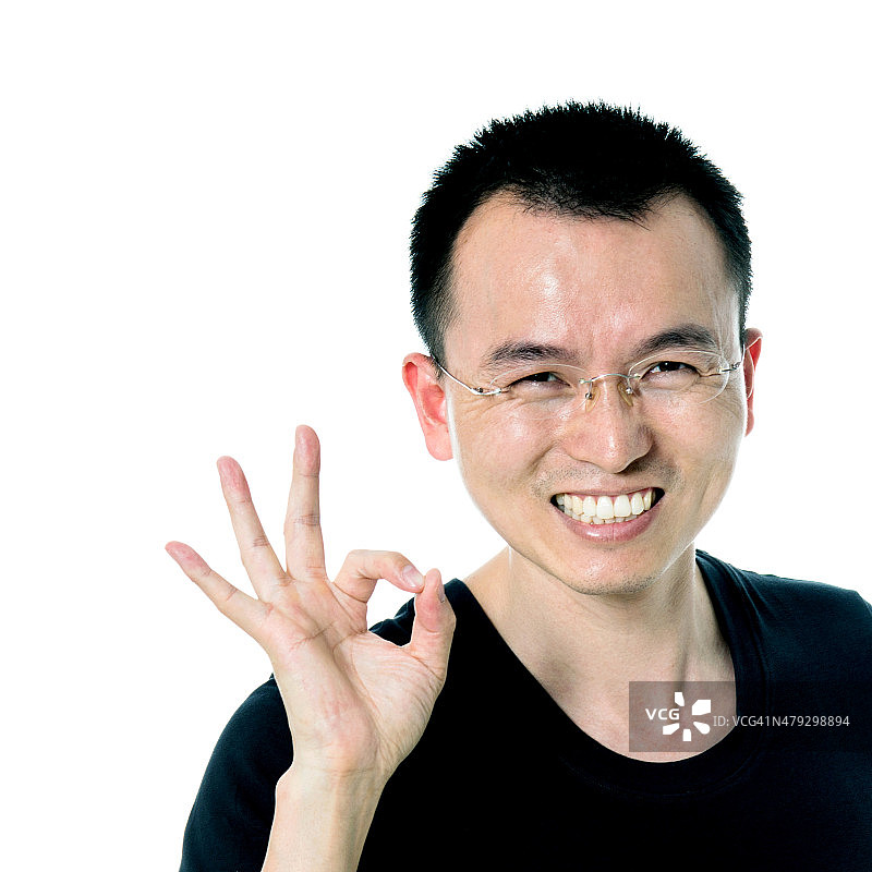 年轻的亚洲人给OK手势图片素材