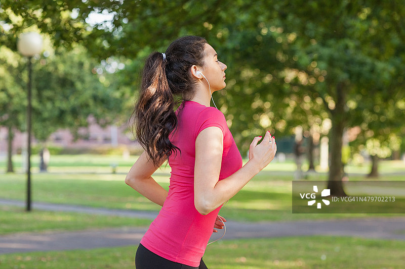 一个严肃的运动型女人在公园慢跑图片素材