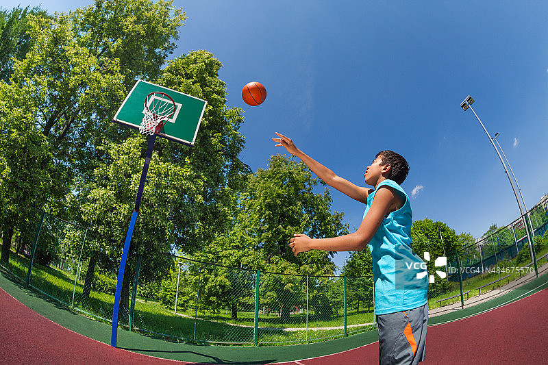 阿拉伯男孩带着球飞向篮球目标图片素材