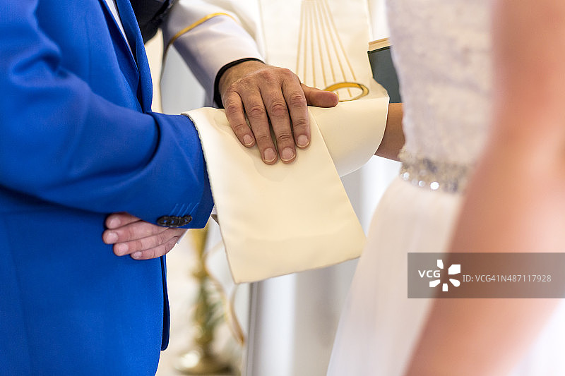 新婚夫妇和牧师手牵手的婚礼图片素材
