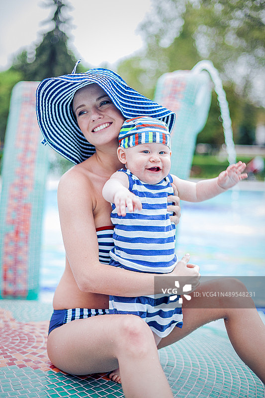 快乐的男孩和妈妈在游泳池里图片素材