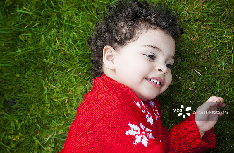 人物:婴儿(2-3)躺在草地上的肖像。图片素材