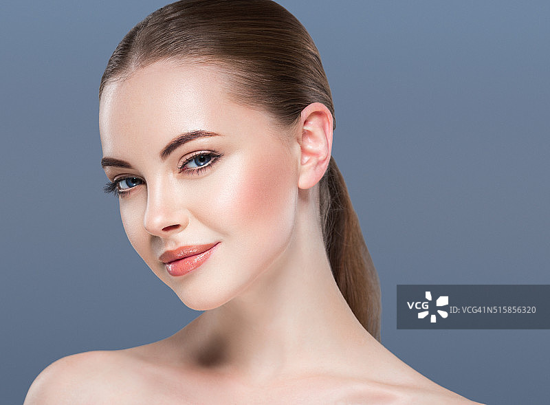 女性美丽肖像皮肤护理概念上的蓝色背景。图片素材