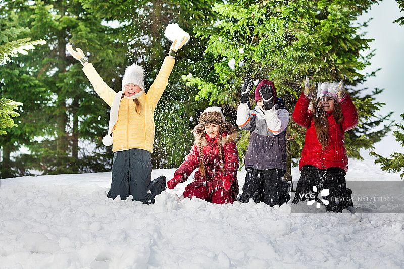 快乐的孩子们在阳光明媚的冬日跪着图片素材