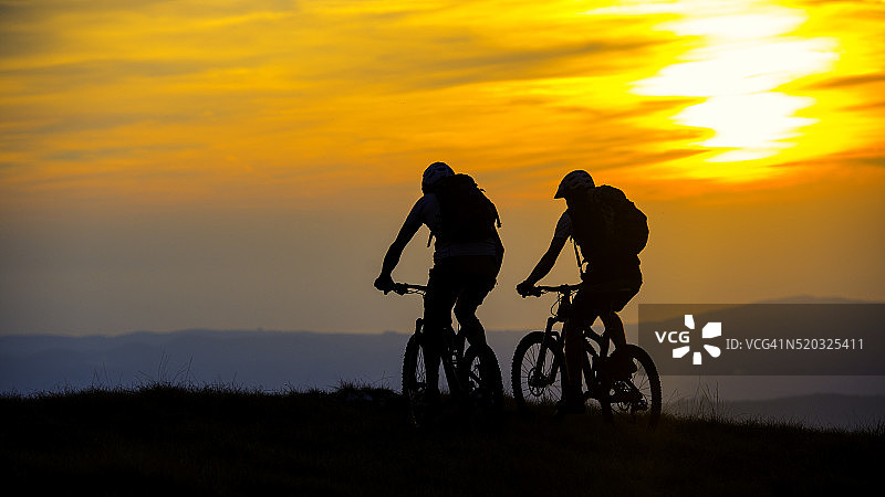 骑自行车的人在山顶的日落图片素材