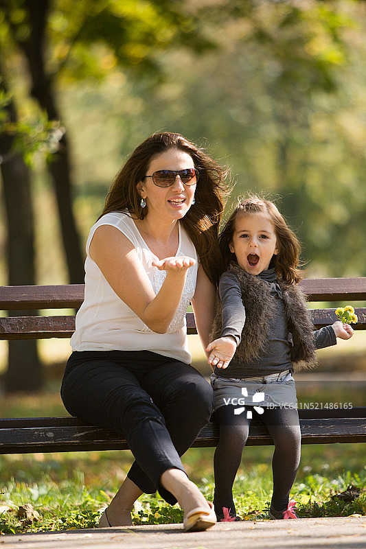 母亲和女儿坐在长凳上图片素材