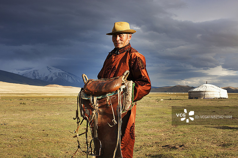 手持马鞍的蒙古人图片素材