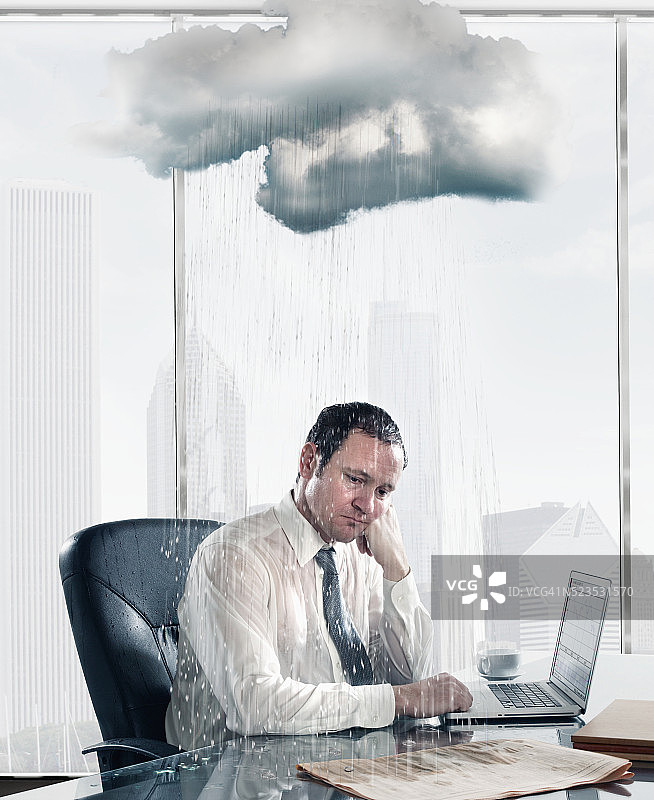 雨落在坐在办公室办公桌前的悲伤的商人身上图片素材