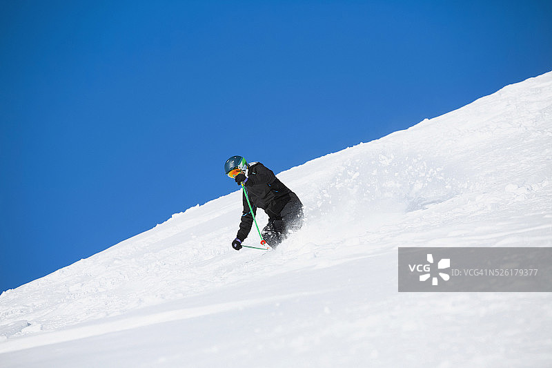 男子滑雪者，雪道外滑雪粉雪，阳光明媚的滑雪场图片素材