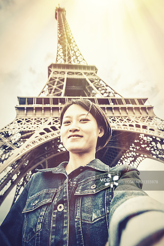 年轻的中国女游客站在埃菲尔铁塔前图片素材