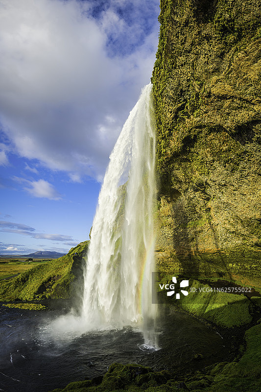 瀑布从悬崖上倾泻而下进入冰岛Seljalandsfoss田园诗般的池塘图片素材