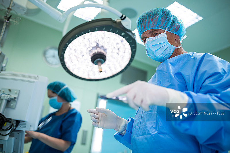 外科医生在手术室中手持手术工具图片素材