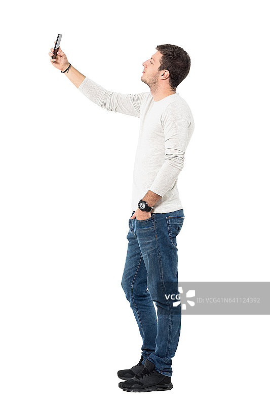 年轻人用手机自拍的侧视图图片素材