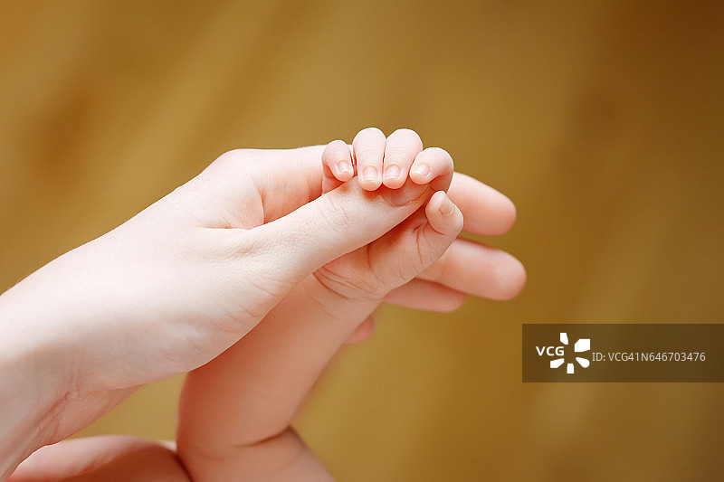 新生儿的手握在母亲的手里。妈妈和孩子。图片素材