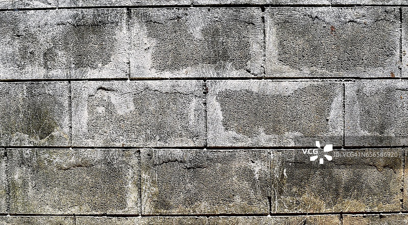 混凝土墙粗糙的灰色表面上有划痕和黑色污垢图片素材