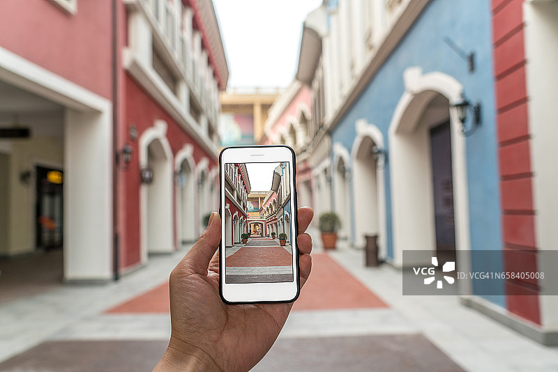 增强现实营销街。手持智能手机使用AR应用检查信息图片素材