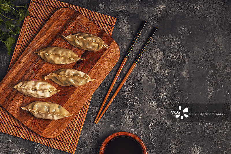 新鲜的饺子在一个黑色的石头背景。图片素材