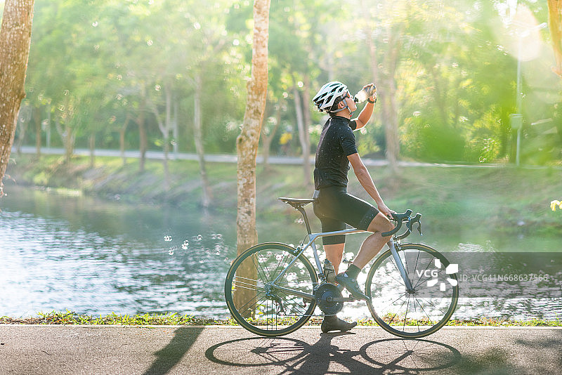 年轻的骑自行车的人在早上骑山地车在小径上图片素材