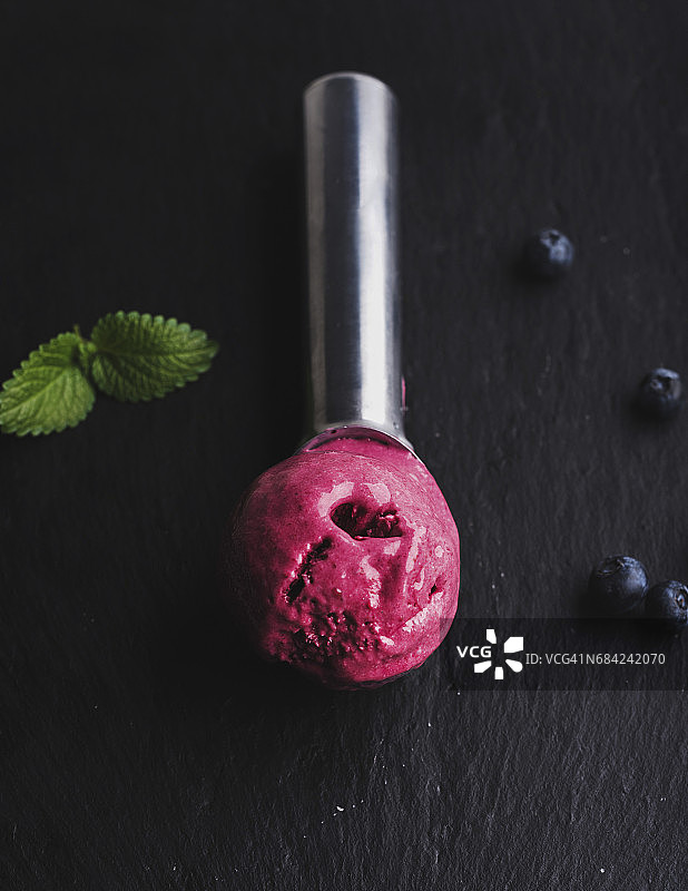 蓝莓冰淇淋勺在黑色石板石的背景图片素材