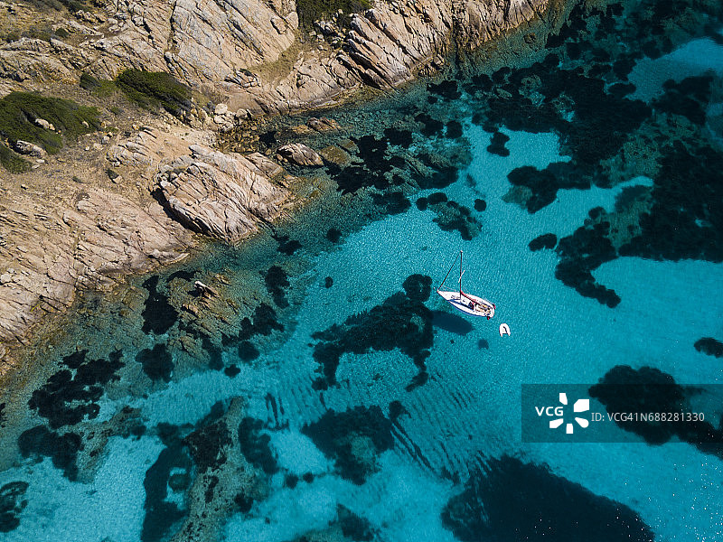 撒丁岛莫里托里奥岛前一艘船的鸟瞰图。令人惊叹的海滩，绿松石和透明的大海。翡翠海岸，撒丁岛，意大利。图片素材