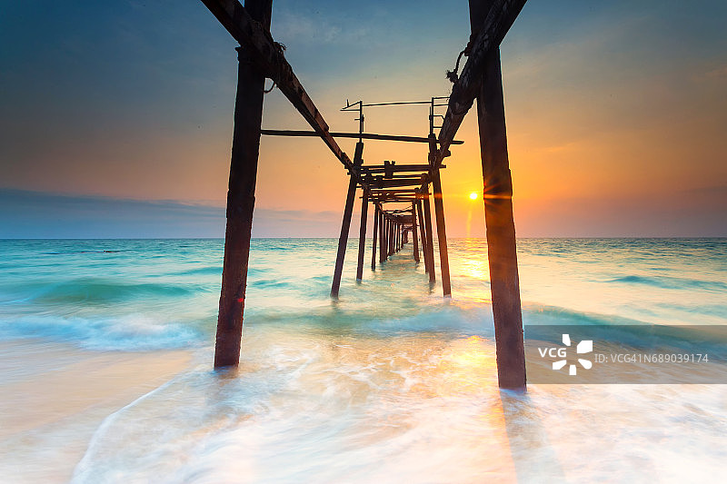 泰国普吉岛，日落时分海滩上的木桥图片素材