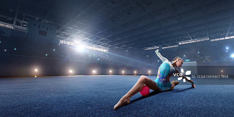 体操女运动员在大型专业舞台上用体操球进行表演图片素材