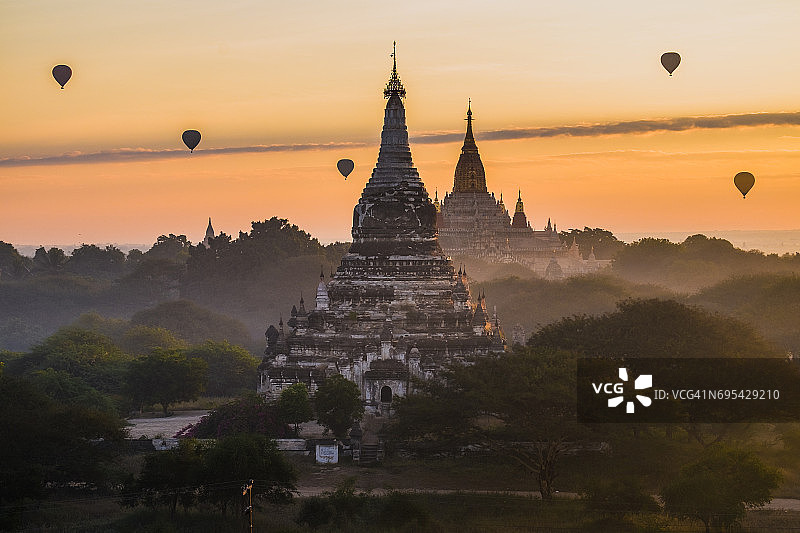 缅甸蒲甘清晨，热气球飞过阿南达寺图片素材