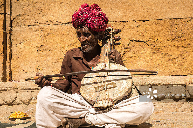 印度拉贾斯坦邦的贾伊萨默堡，一名印度老人在弹奏传统乐器图片素材
