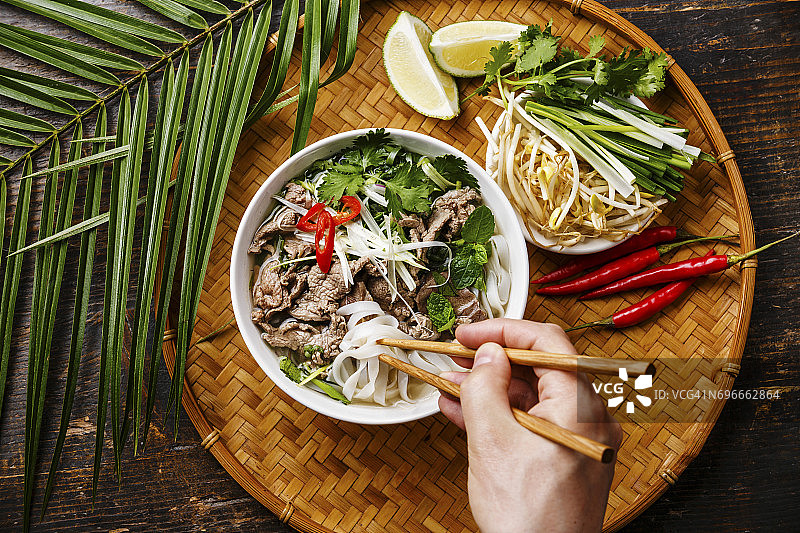 越南牛肉汤，男性手拿筷子图片素材