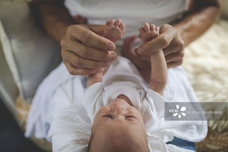 一位父亲优雅地握着他刚出生的婴儿的手图片素材