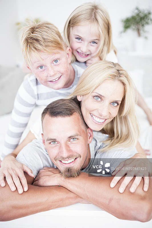 微笑的一家人躺在床上的照片图片素材