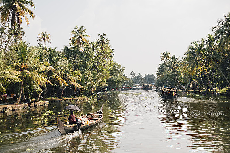 在印度喀拉拉邦库马拉库姆河上乘坐传统船只旅行的人们图片素材