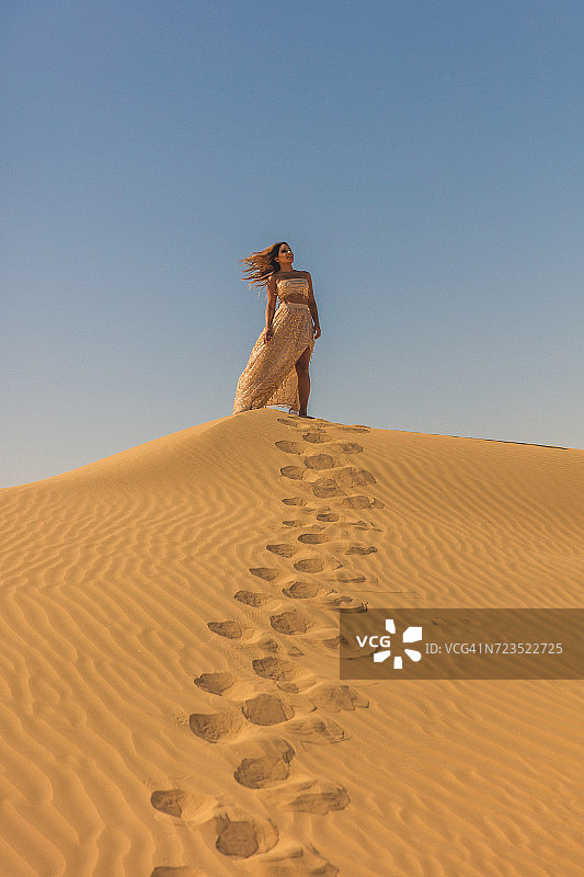 “一个女人在迪拜的沙丘里的肖像”图片素材