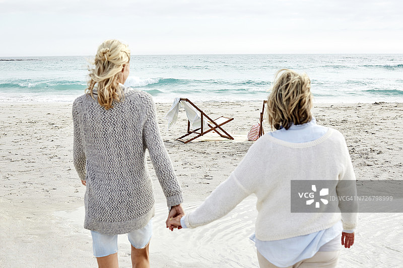 妈妈和女儿手牵着手走在沙滩上图片素材