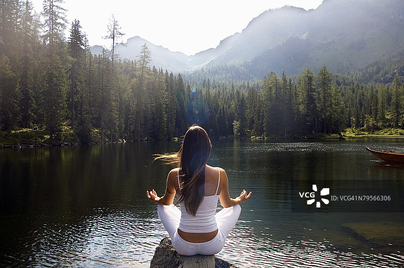 女子在湖边练瑜伽，后视图图片素材