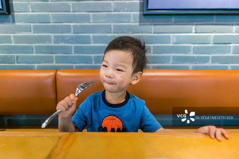 小男孩用叉子吃东西的照片图片素材