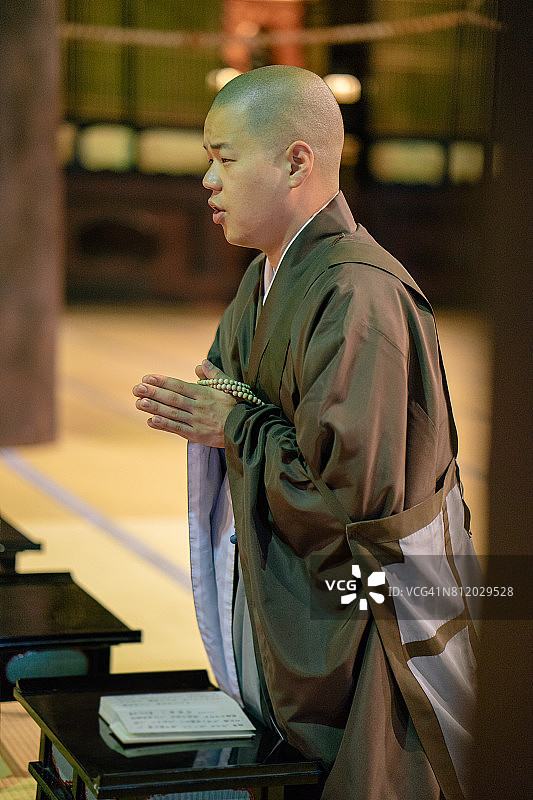 和尚在佛教寺庙内举行的晨会上祈祷图片素材