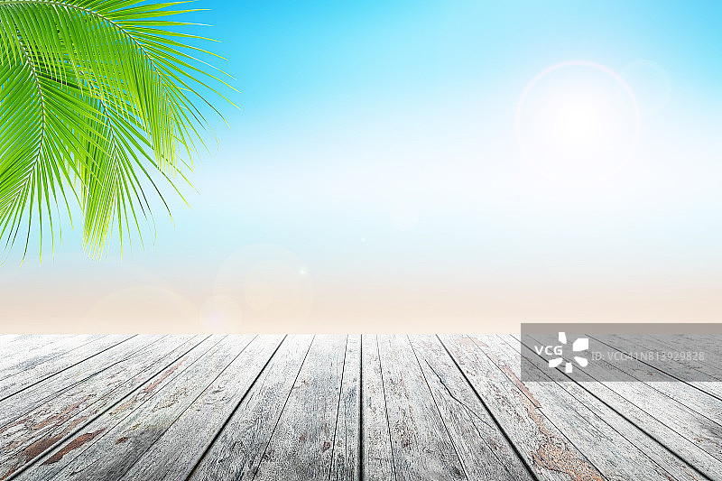 空木桌和棕榈叶与派对的海滩背景模糊。图片素材
