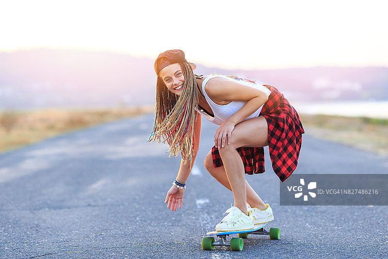 微笑的溜冰者在乡村公路上滑行图片素材